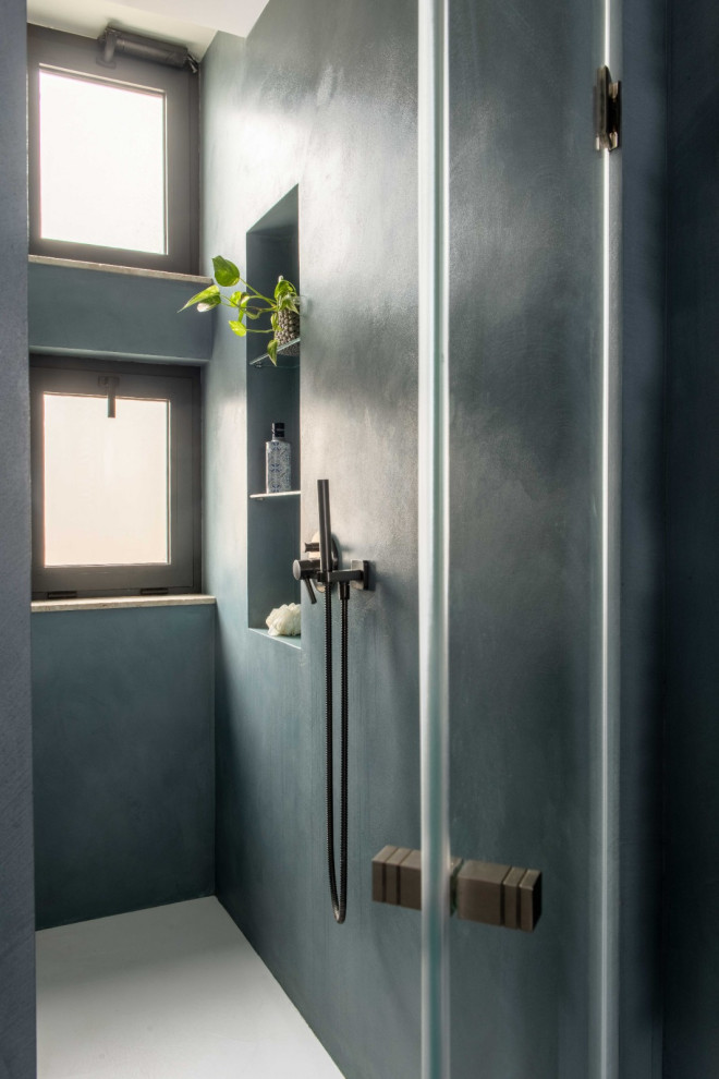 Свежая идея для дизайна: ванная комната среднего размера в стиле фьюжн с плоскими фасадами, синими фасадами, душем без бортиков, инсталляцией, синей плиткой, синими стенами, полом из керамогранита, душевой кабиной, консольной раковиной, столешницей из искусственного камня, синим полом, душем с распашными дверями, белой столешницей, нишей, тумбой под одну раковину, подвесной тумбой и многоуровневым потолком - отличное фото интерьера