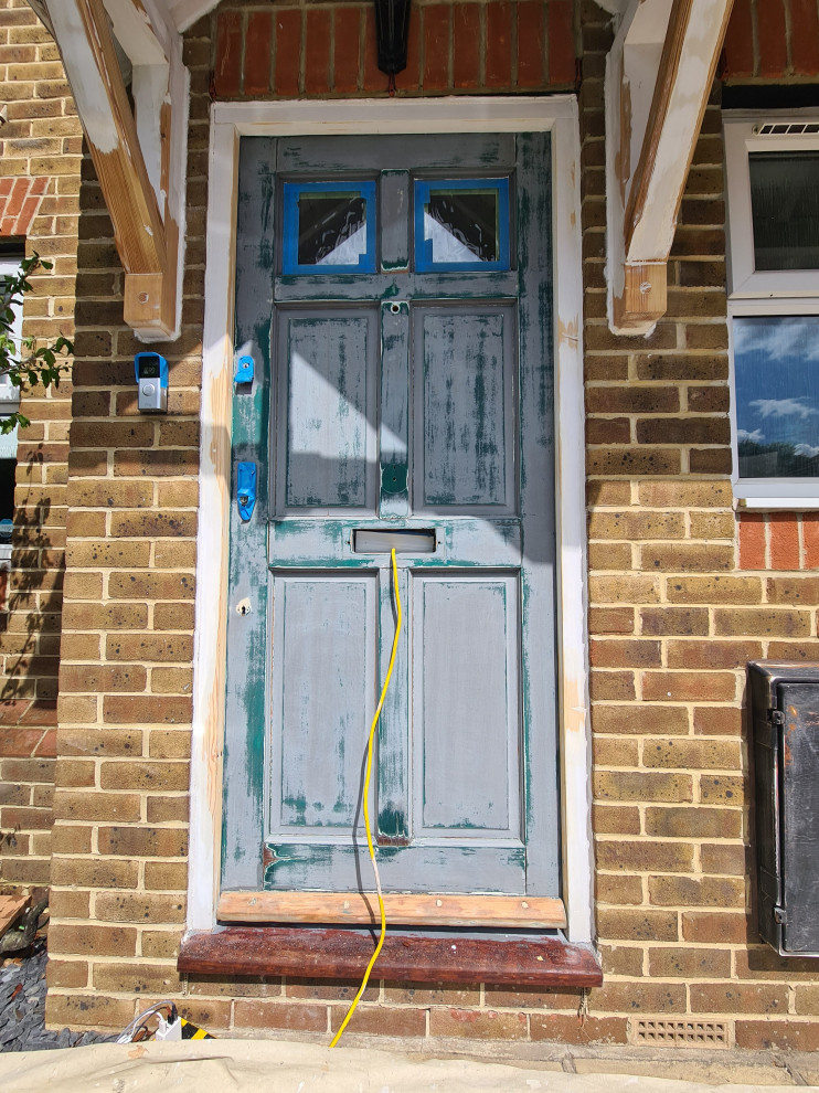 Пример оригинального дизайна: входная дверь среднего размера в классическом стиле с бетонным полом, одностворчатой входной дверью, серой входной дверью и коричневым полом