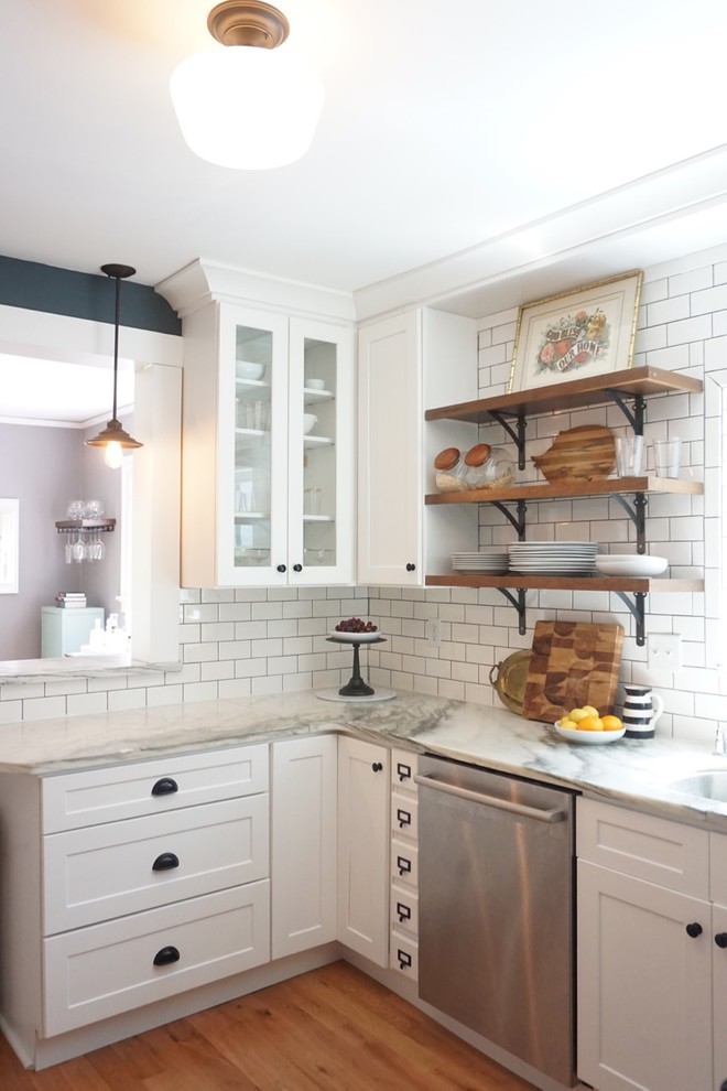 Design ideas for an eclectic kitchen in St Louis with shaker cabinets, white cabinets, marble benchtops, white splashback, subway tile splashback and light hardwood floors.