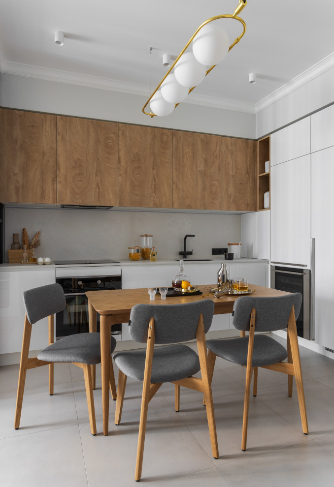 Inspiration for a small contemporary l-shaped eat-in kitchen in Moscow with an undermount sink, flat-panel cabinets, medium wood cabinets, quartz benchtops, white splashback, engineered quartz splashback, black appliances, porcelain floors, grey floor and white benchtop.