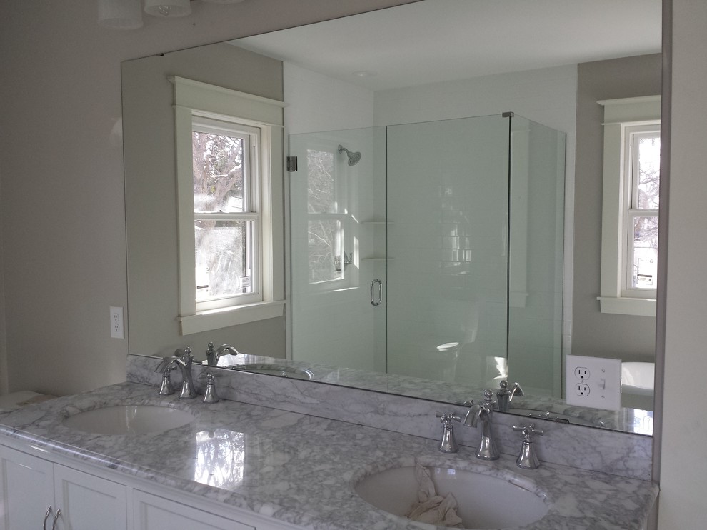 Inspiration for a large transitional master bathroom in Minneapolis with recessed-panel cabinets, white cabinets, white walls, an undermount sink, a freestanding tub, a corner shower and a hinged shower door.