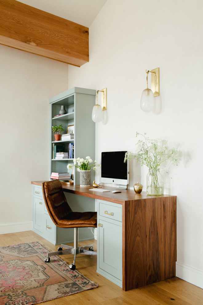 This is an example of a small rustic home office in Denver with a freestanding desk.