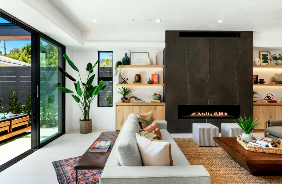 Living room library - large contemporary open concept ceramic tile, white floor and tray ceiling living room library idea in Los Angeles with white walls, a ribbon fireplace and a stone fireplace