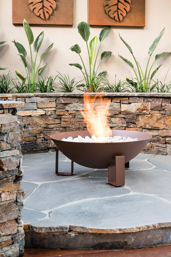 Photo of a mid-sized contemporary backyard garden in Melbourne with a fire feature and natural stone pavers.