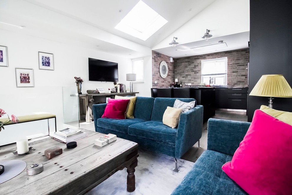 Small modern l-shaped open plan kitchen in London with a single-bowl sink, flat-panel cabinets, black cabinets, composite countertops, brown splashback, brick splashback, stainless steel appliances, medium hardwood flooring, an island, brown floors and black worktops.