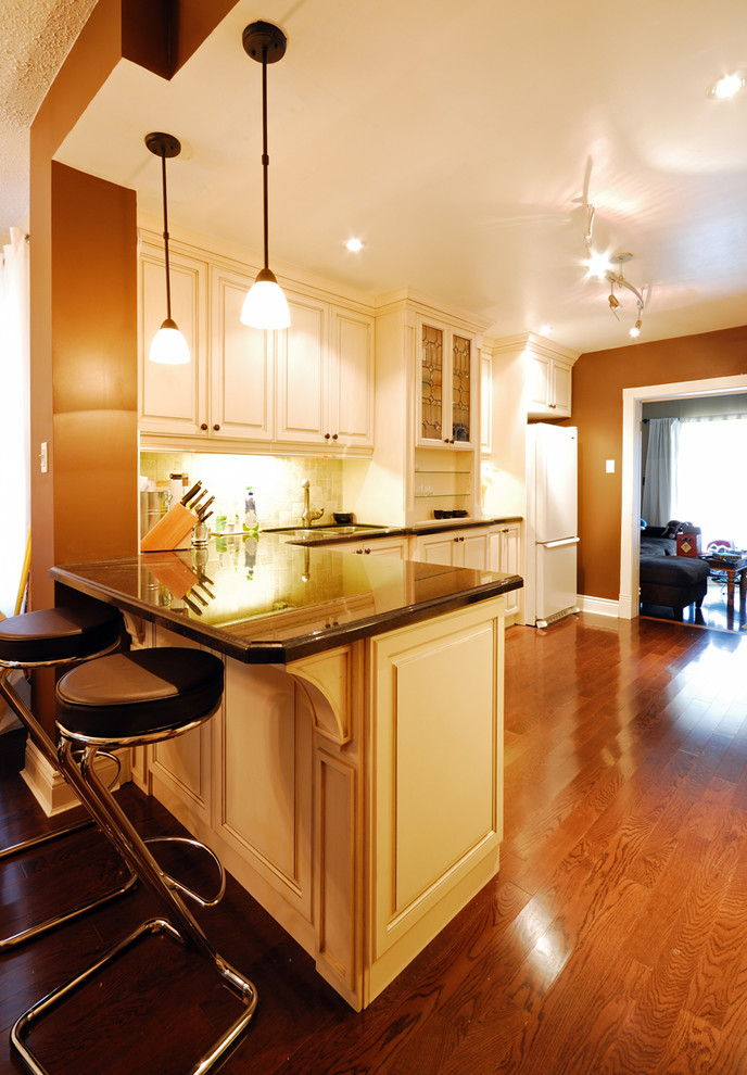 Example of a medium tone wood floor kitchen design in Toronto with beige cabinets, beige backsplash, stainless steel appliances and no island