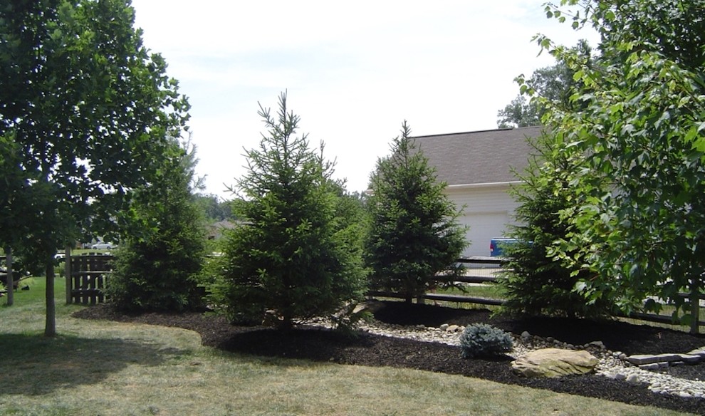 This is an example of a mid-sized transitional full sun backyard stone landscaping in Cincinnati for spring.