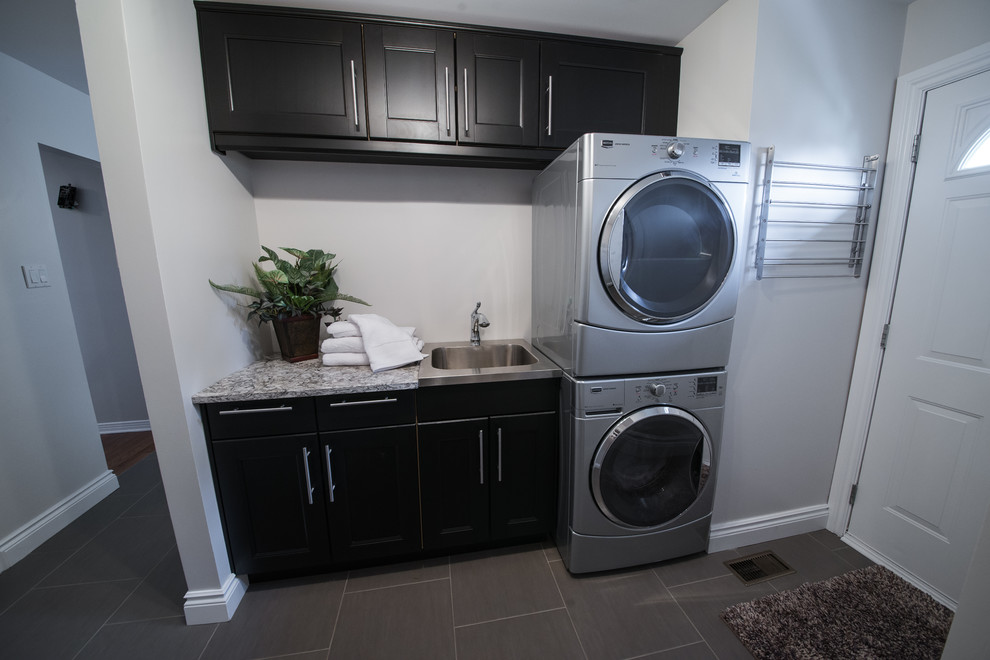 Exempel på en tvättstuga, med en undermonterad diskho, luckor med infälld panel, bänkskiva i kvarts, stänkskydd i glaskakel och klinkergolv i porslin