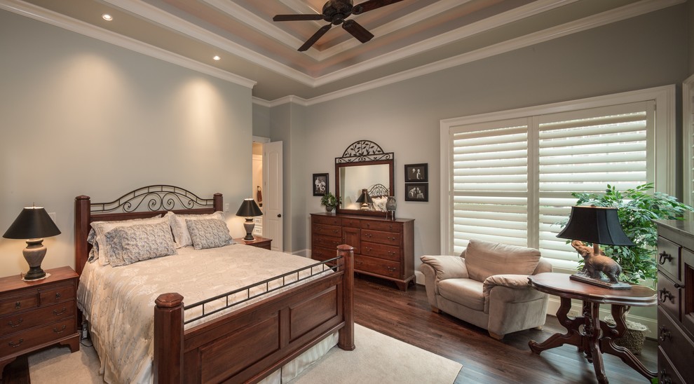 Photo of a mid-sized traditional master bedroom in Houston with blue walls and dark hardwood floors.