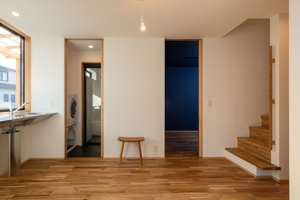 This is an example of a mid-sized scandinavian entry hall in Other with white walls, medium hardwood floors, a sliding front door, a black front door, beige floor, wallpaper and wallpaper.