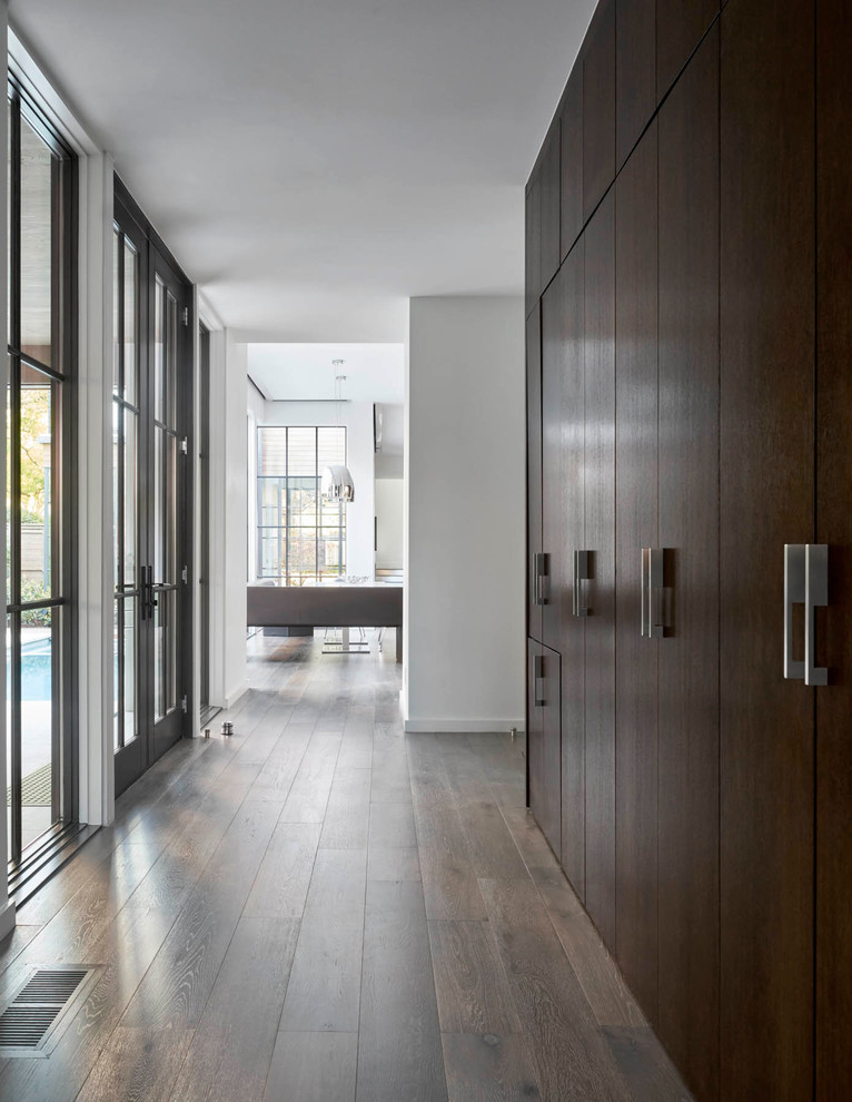 Inspiration for a mid-sized contemporary hallway in Dallas with white walls and dark hardwood floors.