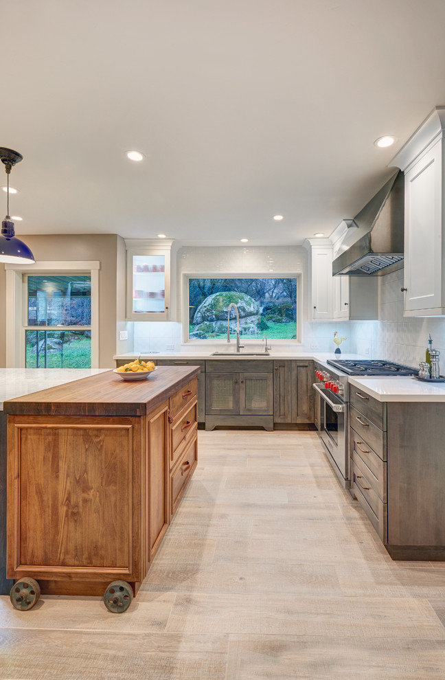 This is an example of a large eclectic u-shaped eat-in kitchen in Sacramento with an undermount sink, recessed-panel cabinets, grey cabinets, quartz benchtops, white splashback, porcelain splashback, stainless steel appliances, porcelain floors and with island.