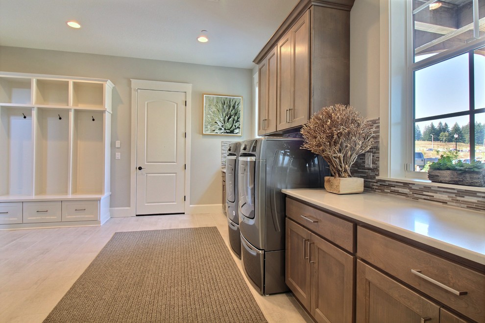 Expansive arts and crafts l-shaped utility room in Portland with a drop-in sink, flat-panel cabinets, brown cabinets, quartz benchtops, grey walls, ceramic floors, a side-by-side washer and dryer, beige floor and white benchtop.