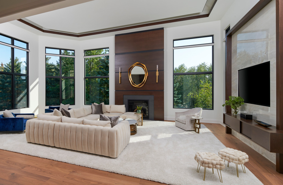 Inspiration for a huge transitional open concept light wood floor and brown floor living room remodel in Detroit with gray walls, a standard fireplace, a wood fireplace surround and a media wall