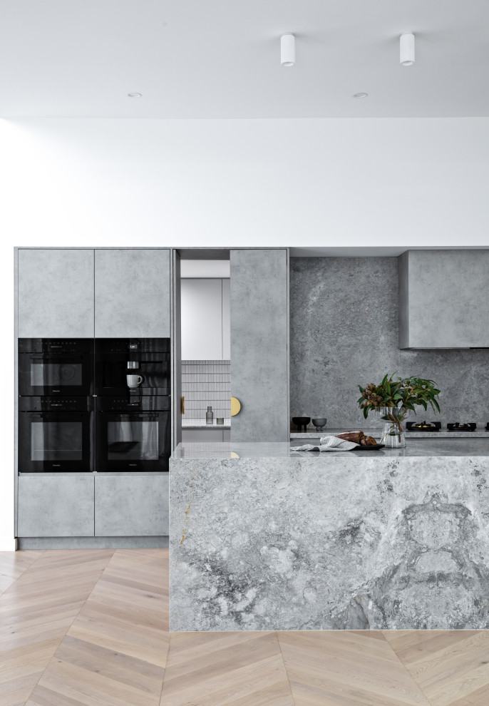 Inspiration for a large mediterranean l-shaped separate kitchen in Sydney with an undermount sink, grey cabinets, marble benchtops, grey splashback, marble splashback, black appliances, with island and grey benchtop.