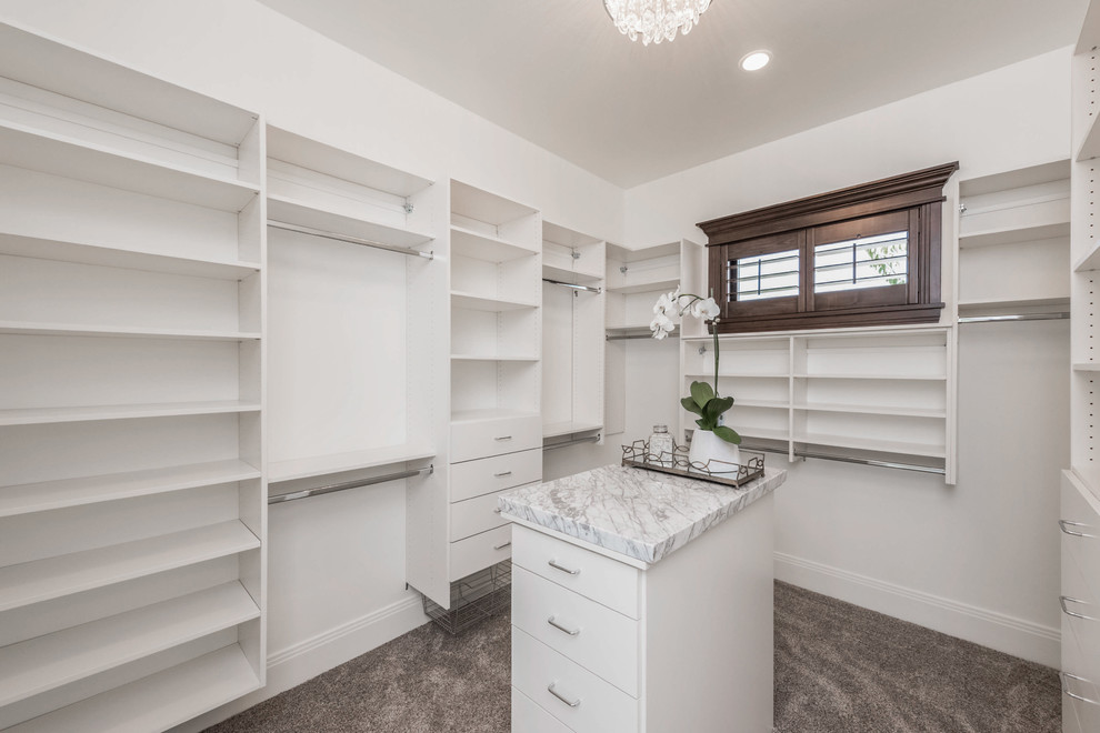 Inspiration for a large traditional gender-neutral walk-in wardrobe in Salt Lake City with flat-panel cabinets, white cabinets, carpet and brown floor.