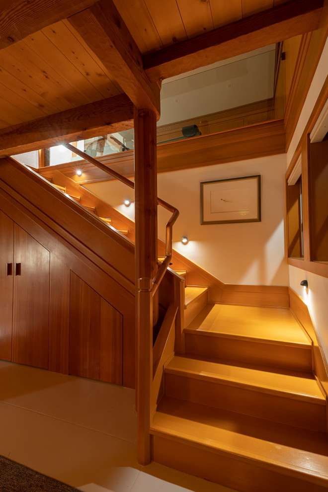 Идея дизайна: угловая деревянная лестница среднего размера в современном стиле с деревянными ступенями, металлическими перилами и панелями на части стены