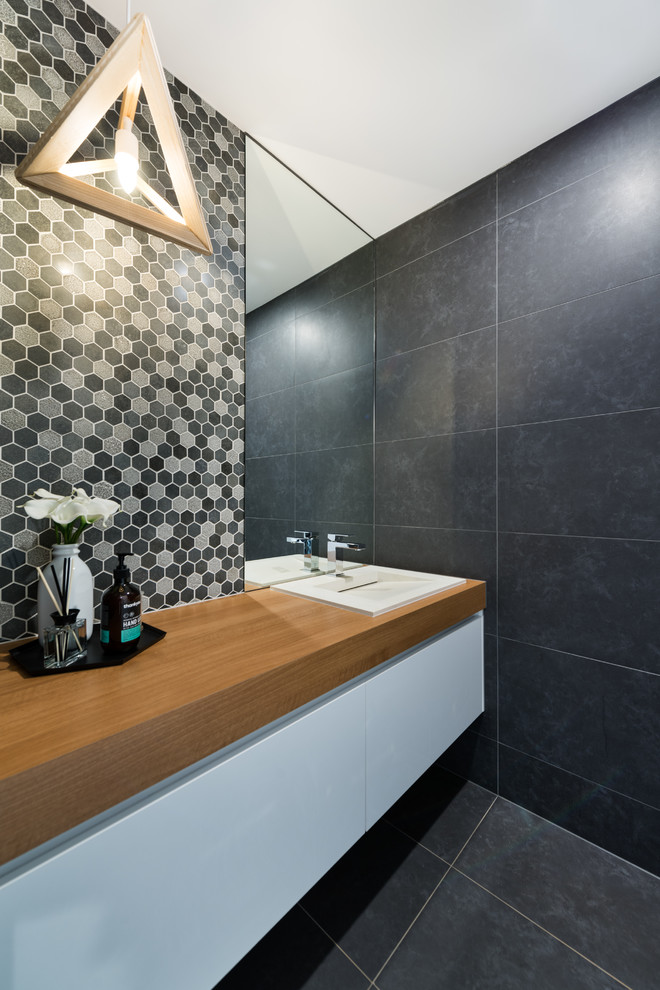 Photo of a large contemporary kids bathroom in Melbourne with furniture-like cabinets, white cabinets, an open shower, gray tile, porcelain tile, white walls, porcelain floors, a vessel sink and wood benchtops.
