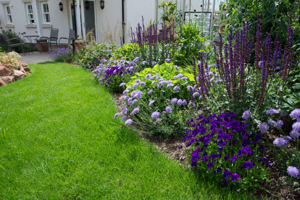 This is an example of a mid-sized country backyard full sun garden for spring in Other with with flowerbed.