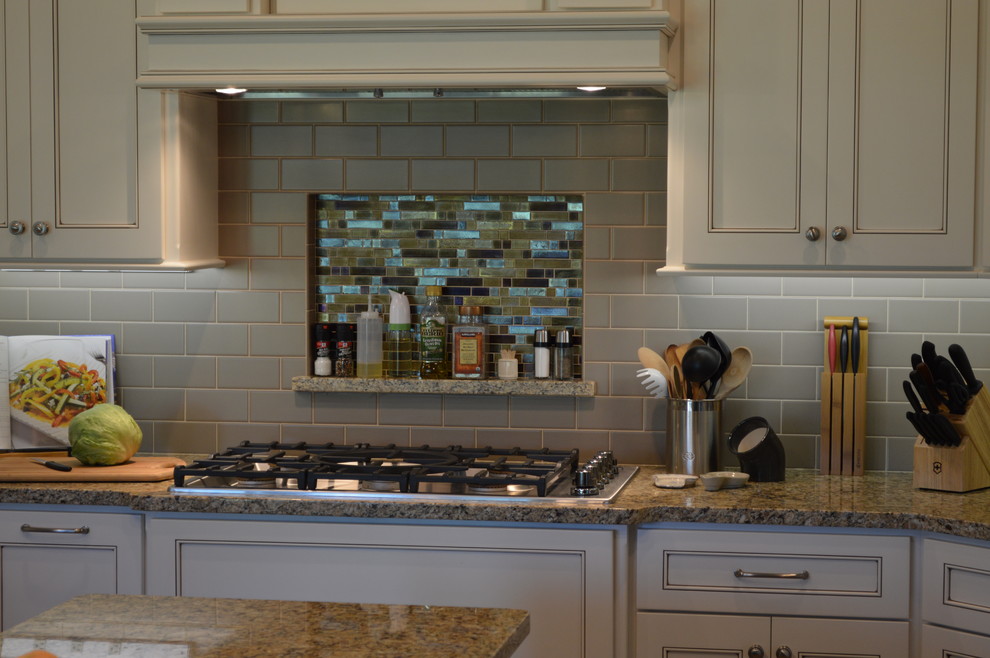 Open concept kitchen - mid-sized traditional u-shaped ceramic tile and brown floor open concept kitchen idea with an undermount sink, beaded inset cabinets, white cabinets, granite countertops, gray backsplash, subway tile backsplash, stainless steel appliances, an island and gray countertops