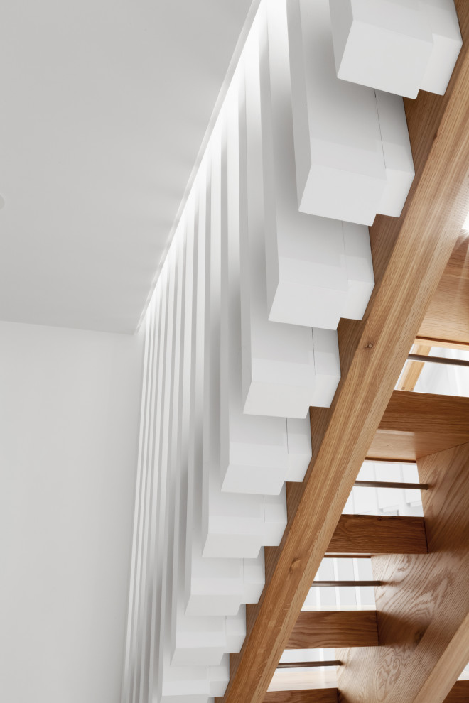 Imagen de escalera en L nórdica de tamaño medio sin contrahuella con escalones de madera, barandilla de madera y madera