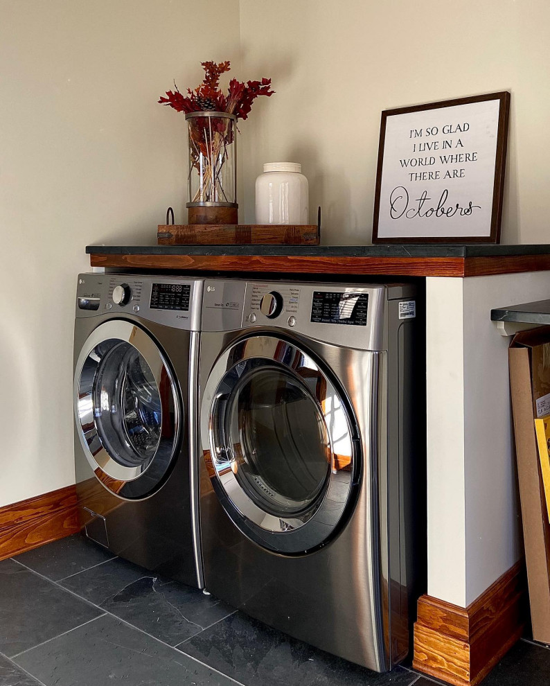 Mid-sized traditional laundry room in Chicago with shaker cabinets, white cabinets, soapstone benchtops, beige walls, a side-by-side washer and dryer and black benchtop.