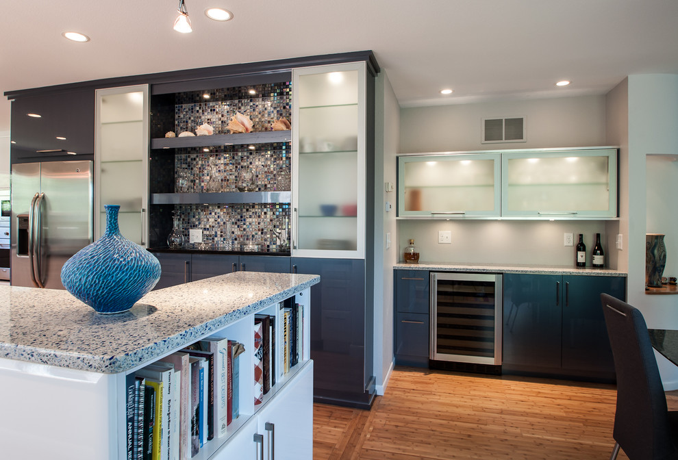 This is an example of a contemporary galley eat-in kitchen in Cedar Rapids with an undermount sink, glass-front cabinets, blue cabinets, recycled glass benchtops, multi-coloured splashback, mosaic tile splashback and stainless steel appliances.