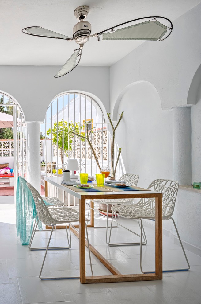 Photo of a mid-sized mediterranean separate dining room in Malaga with white walls, ceramic floors and no fireplace.