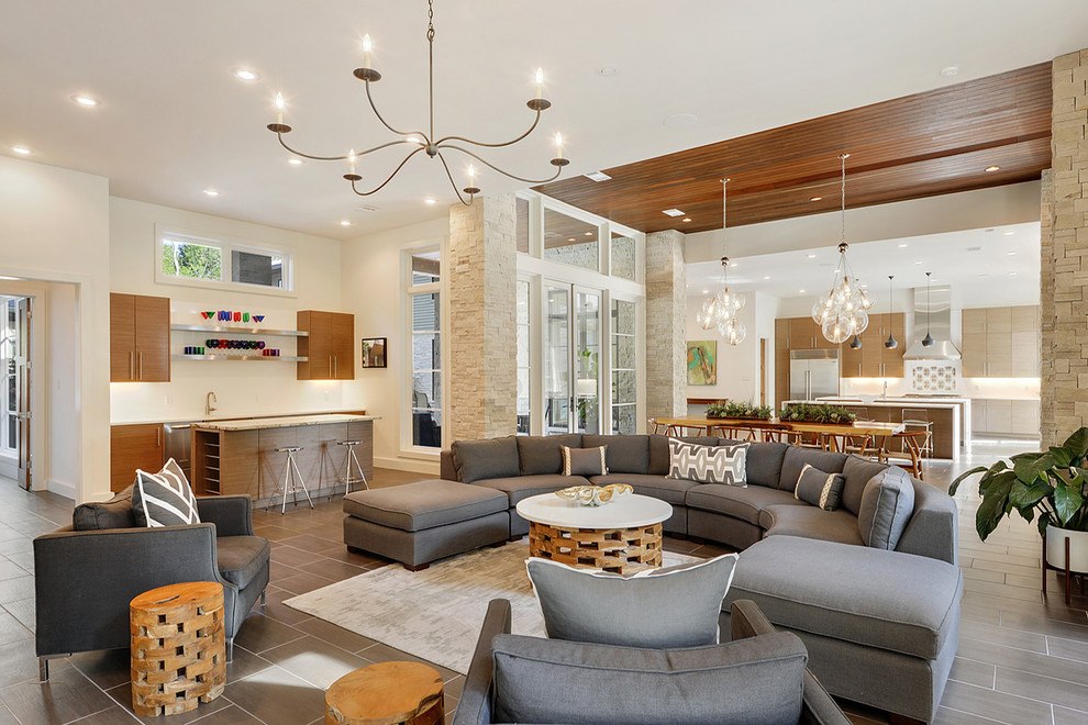 Contemporary open concept family room in New Orleans with a home bar and beige walls.