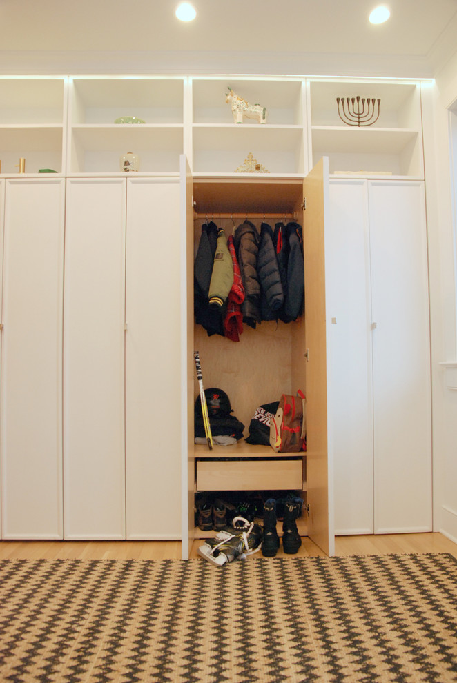 Small transitional mudroom in New York with white walls, light hardwood floors and coffered.