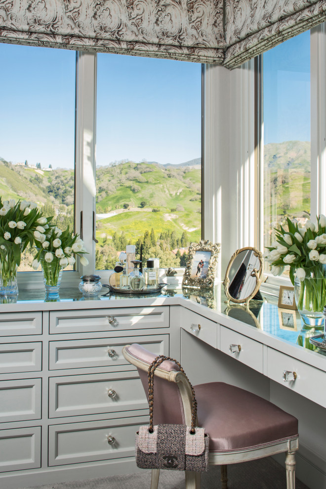 This is an example of a mediterranean women's dressing room in Los Angeles with recessed-panel cabinets and grey cabinets.