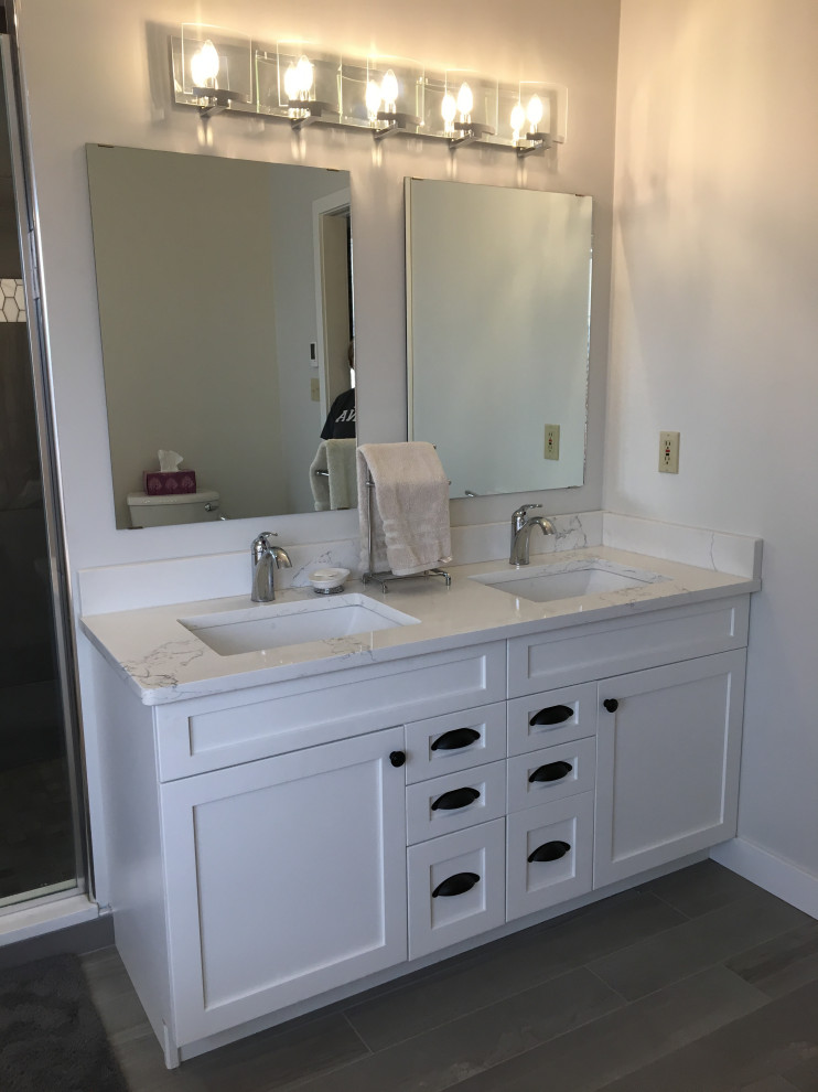 Example of a mid-sized transitional master gray tile and ceramic tile gray floor and double-sink freestanding bathtub design with shaker cabinets, white cabinets, a two-piece toilet, an undermount sink, quartzite countertops, a hinged shower door, a built-in vanity, white walls and white countertops