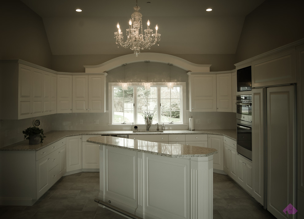 Kitchen - mid-sized transitional u-shaped kitchen idea in Boston with an undermount sink, raised-panel cabinets, white cabinets, granite countertops, stainless steel appliances and an island