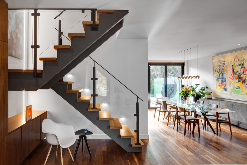 This is an example of a mid-sized contemporary wood u-shaped staircase in Toronto.