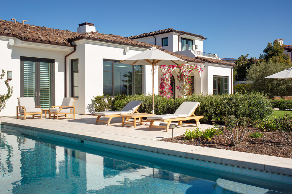 Design ideas for a mediterranean backyard rectangular lap pool in San Diego with concrete slab.