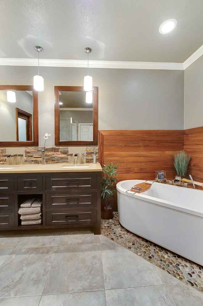 Photo of a contemporary bathroom in Dallas with porcelain tile, pebble tile floors and a freestanding tub.