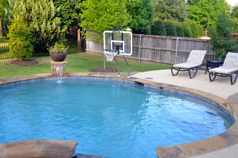 This is an example of a large transitional backyard custom-shaped pool in Dallas with a water feature.