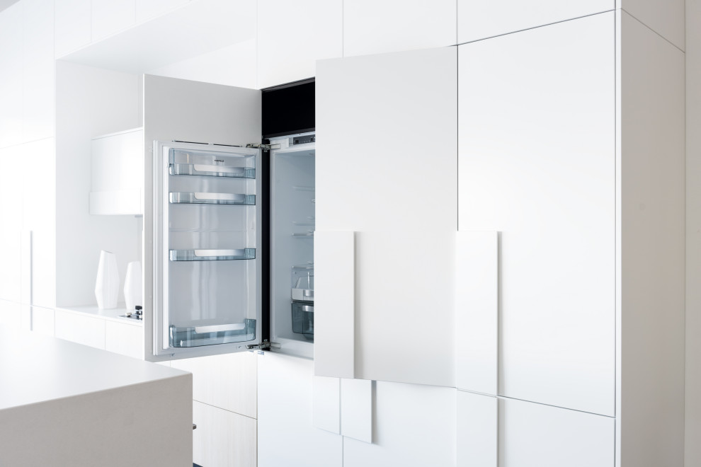 Cette image montre une cuisine parallèle design de taille moyenne avec des portes de placard blanches, un plan de travail en quartz modifié, une crédence blanche, sol en béton ciré, îlot et un plan de travail blanc.