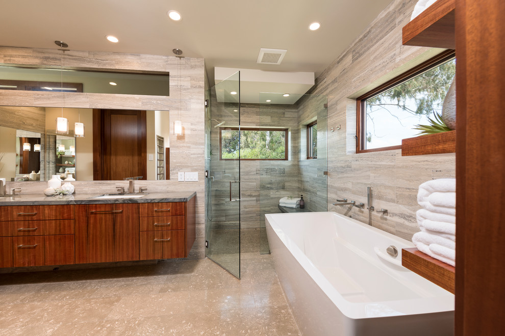Design ideas for a mid-sized modern master bathroom in San Diego with flat-panel cabinets, brown cabinets, a freestanding tub, a curbless shower, green tile, limestone, limestone floors, an undermount sink and limestone benchtops.