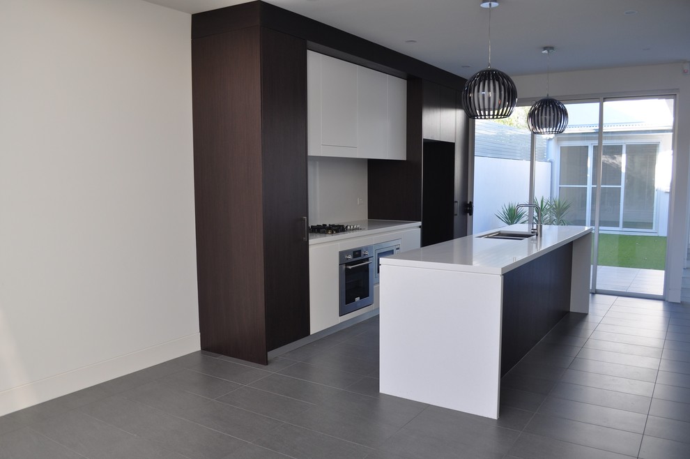 Photo of a contemporary kitchen in Sydney with flat-panel cabinets, laminate benchtops, white splashback, ceramic floors and with island.