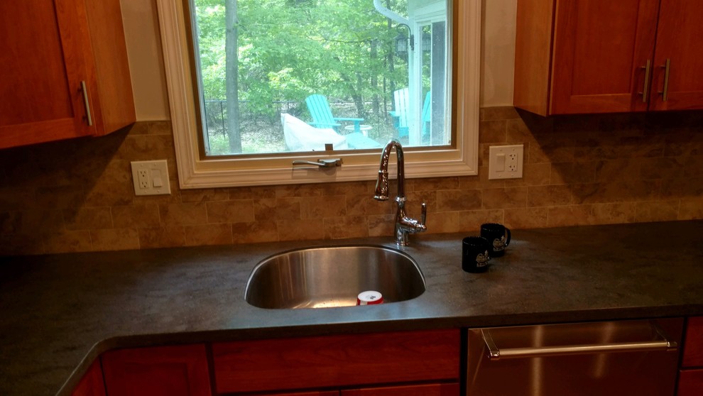 Kitchen - modern kitchen idea in New York with an undermount sink, shaker cabinets, solid surface countertops, beige backsplash, ceramic backsplash, stainless steel appliances, an island and gray countertops