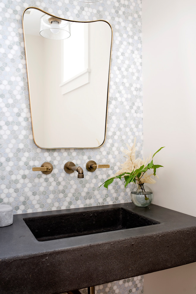 Beach style powder room in Portland Maine with gray tile, multi-coloured tile, white tile, mosaic tile, white walls, an integrated sink and black benchtops.