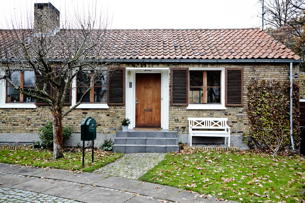 This is an example of a small country one-storey exterior in Aarhus with stone veneer.