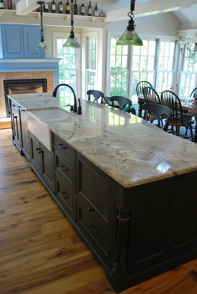 This is an example of a large country l-shaped eat-in kitchen in Boston with a farmhouse sink, beaded inset cabinets, distressed cabinets, granite benchtops, ceramic splashback, panelled appliances, medium hardwood floors and with island.