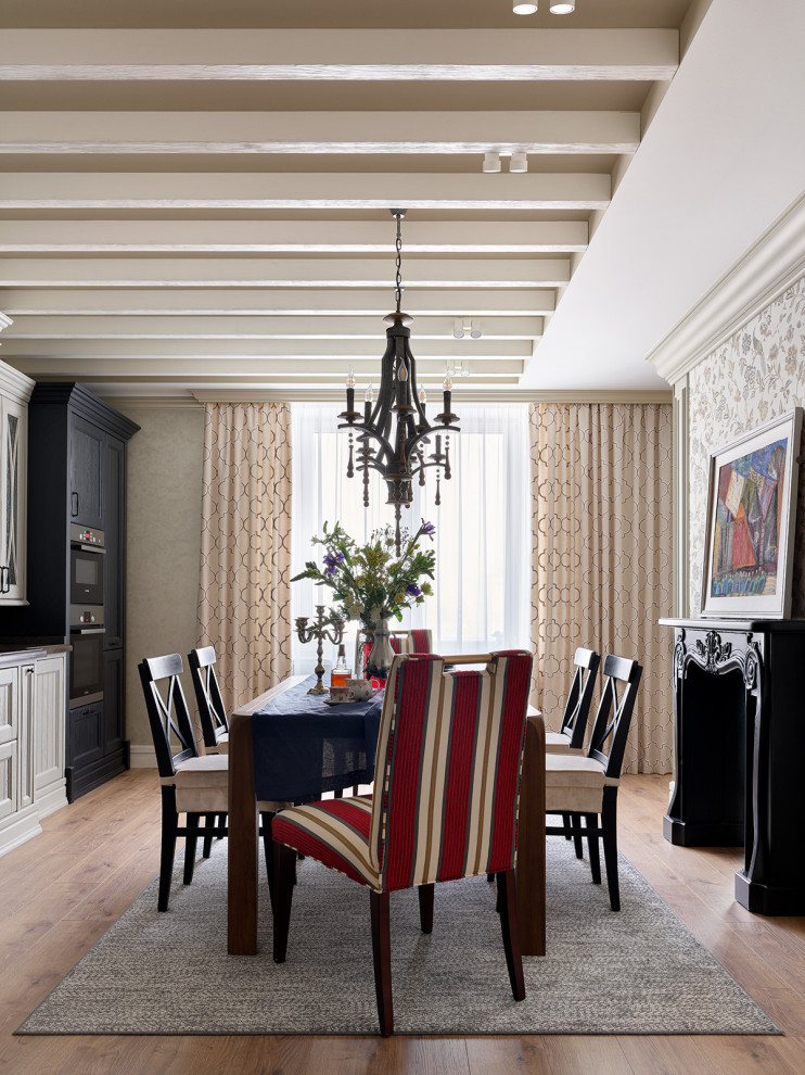 Стильный дизайн: большая кухня-столовая в классическом стиле с серыми стенами, полом из ламината, фасадом камина из дерева, коричневым полом, балками на потолке и обоями на стенах - последний тренд