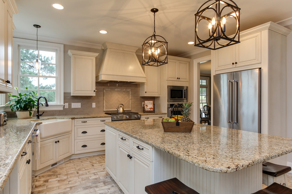 Large country u-shaped eat-in kitchen in Raleigh with a farmhouse sink, shaker cabinets, beige cabinets, granite benchtops, grey splashback, ceramic splashback, stainless steel appliances, brick floors, with island and white floor.