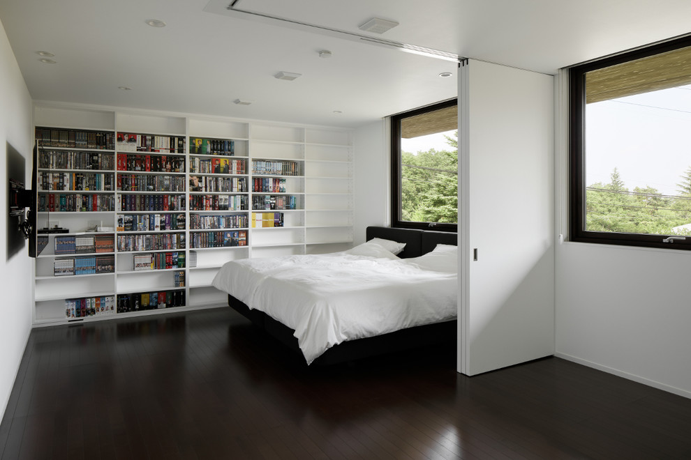 Modern master bedroom in Other with white walls, plywood floors and brown floor.