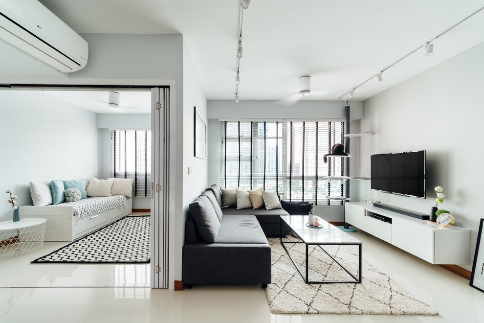 Inspiration for a scandinavian living room in Singapore with grey walls, a wall-mounted tv and beige floor.