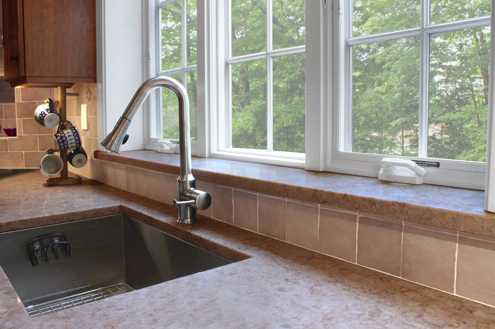 Inspiration for a large transitional u-shaped light wood floor eat-in kitchen remodel in Boston with an undermount sink, shaker cabinets, medium tone wood cabinets, quartz countertops, gray backsplash, porcelain backsplash, stainless steel appliances and a peninsula