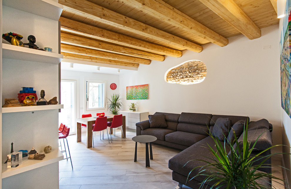 This is an example of a contemporary open concept living room in Bologna with white walls, no fireplace and beige floor.